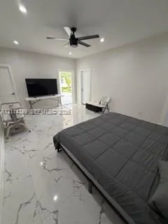 Large-format tile flooring with marble-style veining, recessed lighting, and a modern ceiling fan