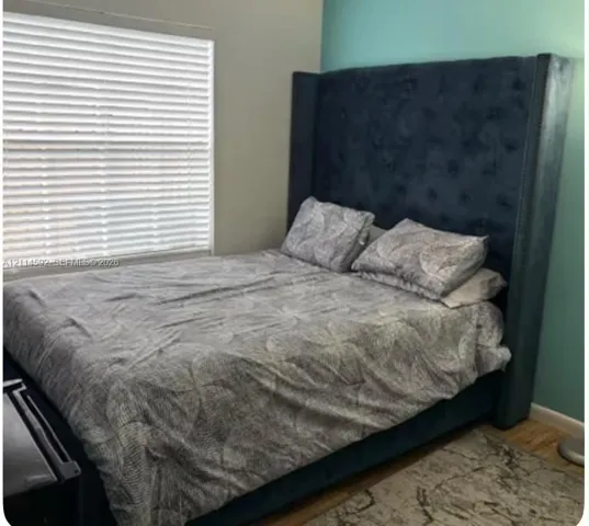 Horizontal window with installed blinds and wood-finish flooring