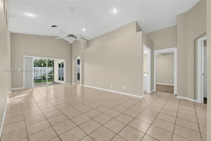 Interior space featuring vaulted ceilings, tile flooring, recessed lighting, a ceiling fan, and sliding glass doors