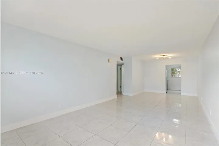 Neutral-toned interior featuring large-format tile flooring and a ceiling-mounted light fixture