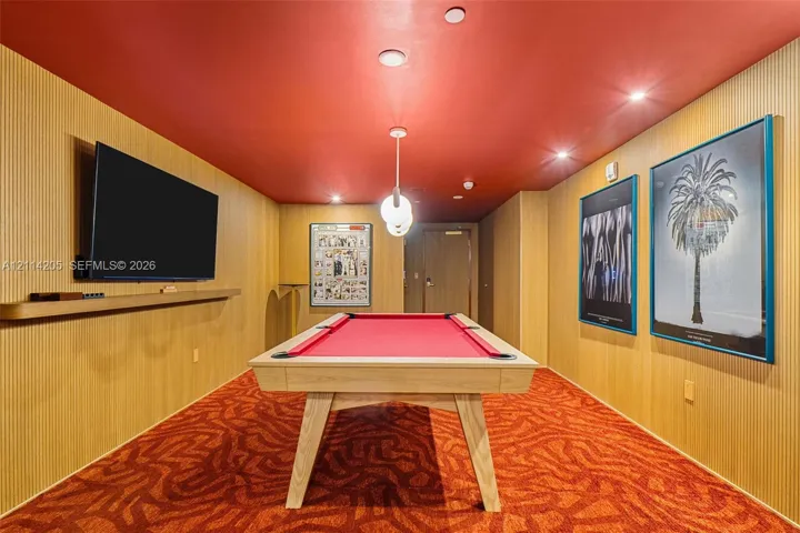 Vertical wood-paneled walls, bold red ceiling, recessed lighting, modern globe pendant fixture, and integrated wall-mounted shelf