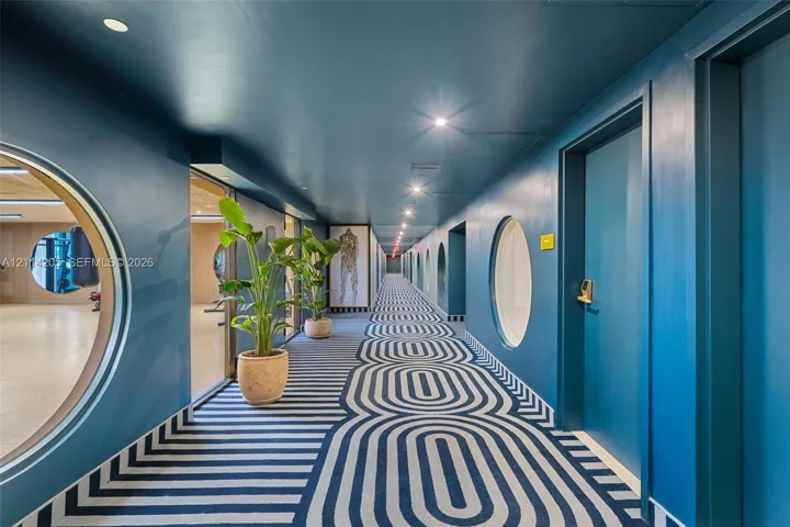 Hallway featuring circular window cutouts, recessed lighting, and patterned carpeting
