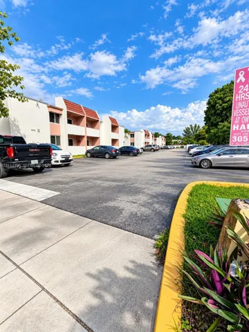 Asphalt-paved surface lot featuring marked parking stalls and concrete curbing