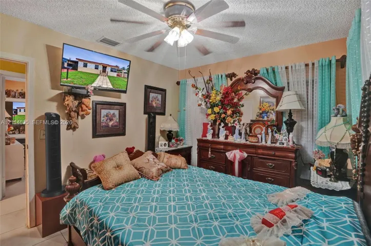 Bedroom featuring a ceiling fan with integrated lighting and neutral-toned wall paint