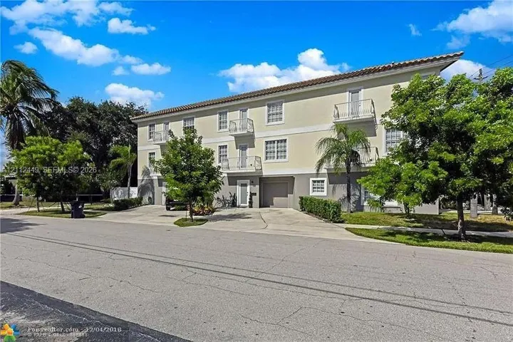 Multi-level exterior featuring a tile roof, stucco facade and private balconies.
