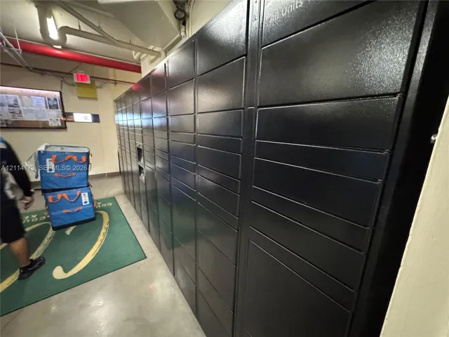 Secure metal parcel storage lockers featuring a matte black finish and integrated electronic kiosk interface