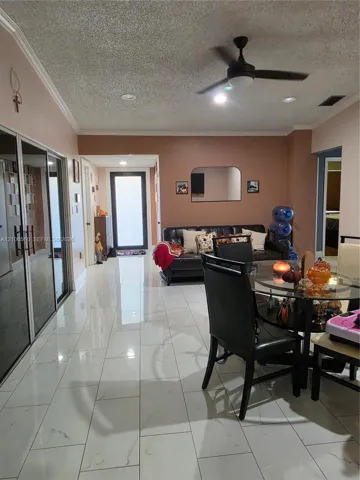 Large-format white tile flooring, ceiling fan with integrated lighting, recessed lighting, and expansive mirrored closet doors