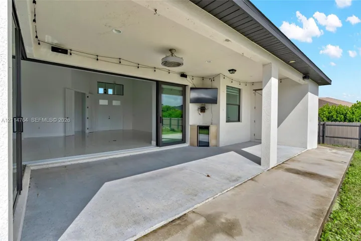 Covered patio featuring concrete flooring, a ceiling fan, recessed lighting, and a built-in outdoor beverage refrigerator