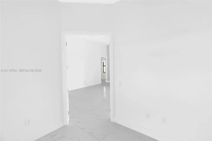 Interior room featuring white walls and white large-format tile flooring