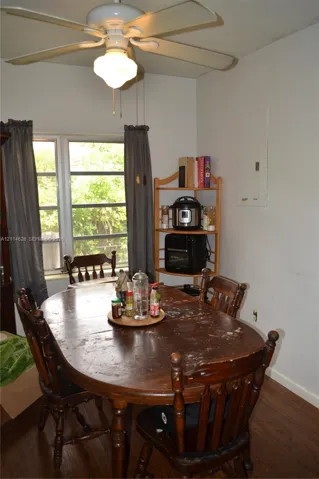 Multi-pane window with wood-finish flooring and a central ceiling fan with integrated lighting