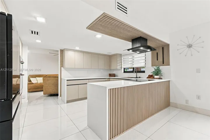 Kitchen featuring flat-panel cabinetry, quartz countertops, slatted wood paneling on the island and ceiling, recessed lighting, and large-format tile flooring