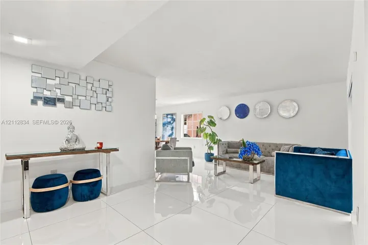 Open interior featuring large-format white tile flooring, neutral wall finishes, and recessed lighting