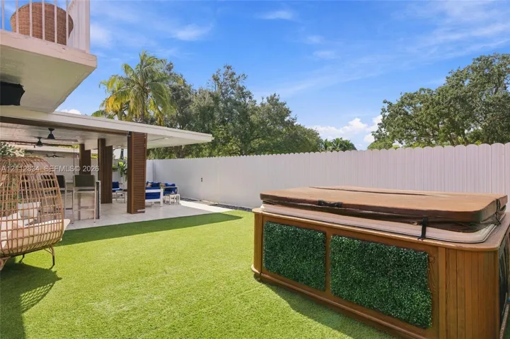 Covered patio with recessed lighting, synthetic turf lawn, and vinyl perimeter fencing