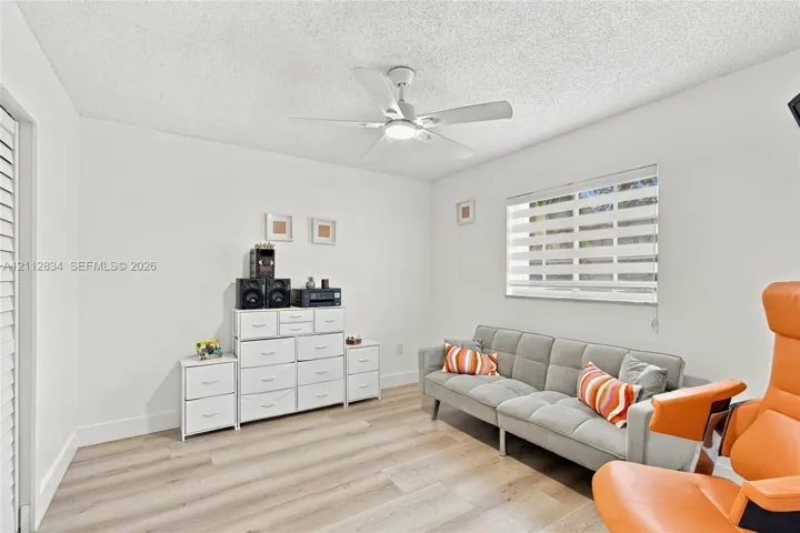 Wood-finish flooring, ceiling fan with integrated lighting, and horizontal window blinds