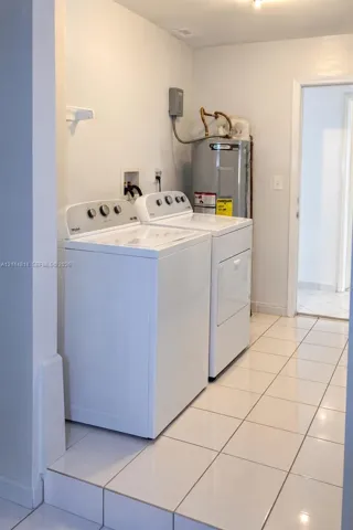 Laundry area featuring white ceramic tile flooring and dedicated washer and dryer hookups