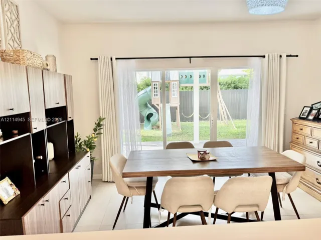 Built-in wood-finish cabinetry, sliding glass doors, and light-tone tile flooring