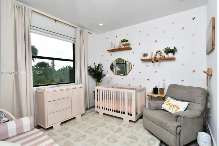 Bedroom featuring two natural wood floating shelves, an organic-shaped wall mirror, a large window, and recessed ceiling lighting