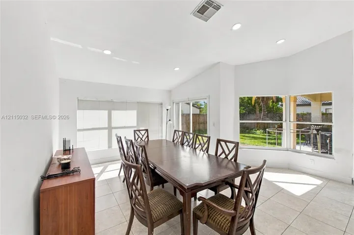 Vaulted ceilings with recessed lighting, tile flooring, and oversized windows