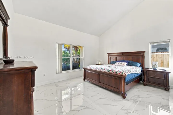 First Floor, Vaulted ceilings, large-format tile flooring with a neutral veining pattern, and dual windows with vertical blinds