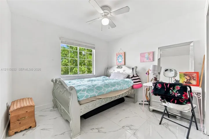 White stone-finish flooring, multi-pane window, and white ceiling fan with integrated light fixture