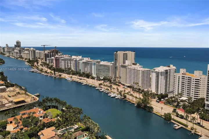 Aerial perspective featuring expansive waterway frontage, deep-water access for nautical vessels, palm-lined coastal topography, and a backdrop of the open ocean