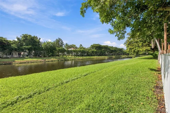 Waterfront parcel featuring extensive lawn, mature trees, and canal frontage