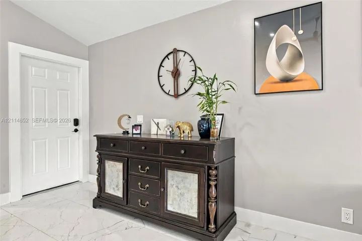 Entryway featuring white six-panel door and large-format polished tile flooring with veining