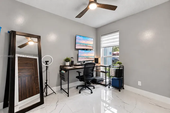 Polished tile flooring with veining, neutral interior paint, and a modern ceiling fan with integrated lighting