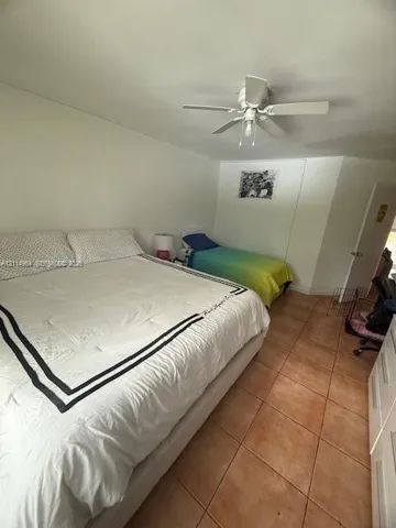 Ceramic tile flooring and a ceiling-mounted fan with integrated lighting