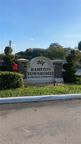 Community entrance signage featuring stone masonry pillars and manicured landscaping