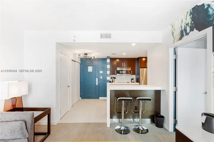 Kitchen featuring a breakfast bar, flat-panel cabinetry, stainless steel appliances, and a built-in microwave