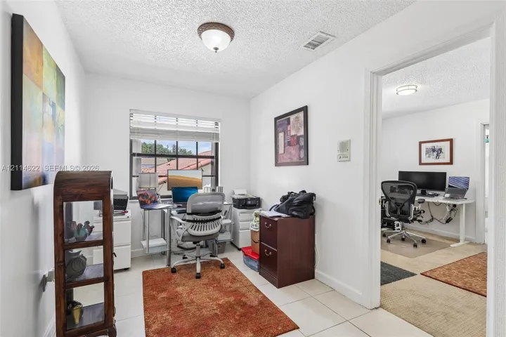 Interior room featuring white walls, tile flooring, and a multi-pane window with interior blinds