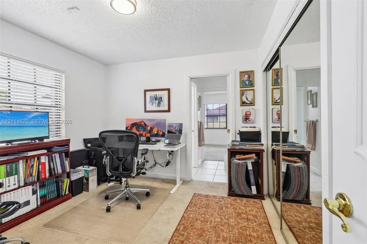Carpeted flooring, mirrored sliding closet doors, and windows with horizontal blinds