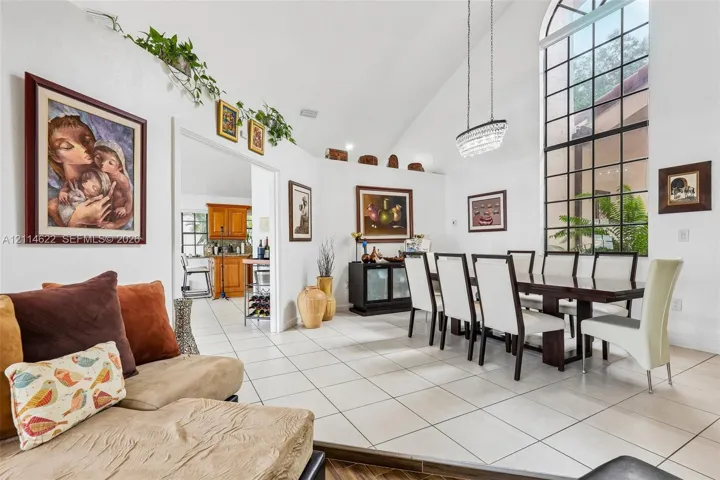 Vaulted ceilings, large-format tile flooring, oversized arched grid window, and a linear multi-light pendant fixture