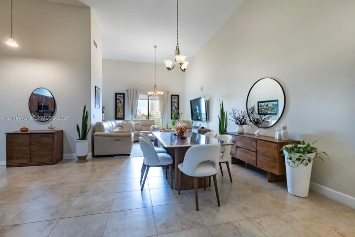 Vaulted ceilings, large-format tile flooring, and multi-arm chandelier lighting