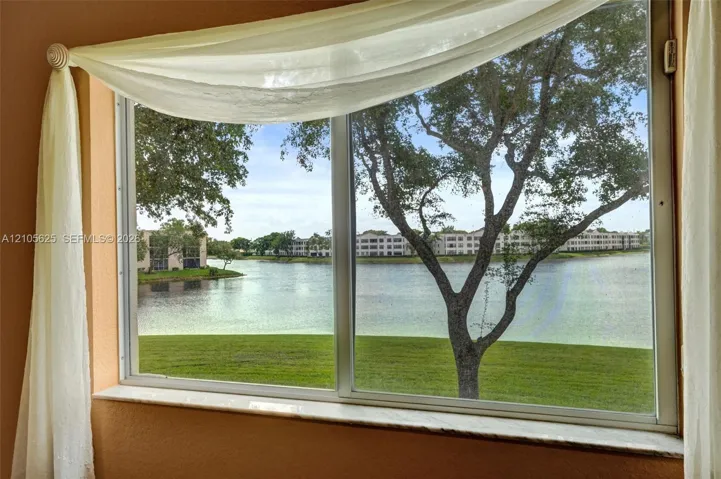 Large window with a stone-finish sill, showcasing water and green space