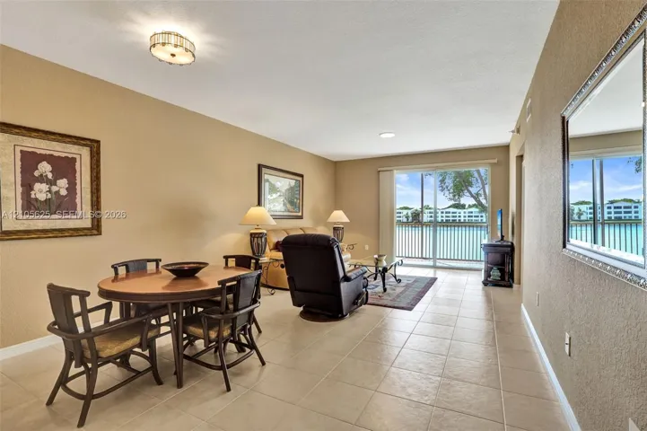 Open-concept interior featuring neutral tile flooring, recessed lighting, and large sliding glass doors providing outdoor access