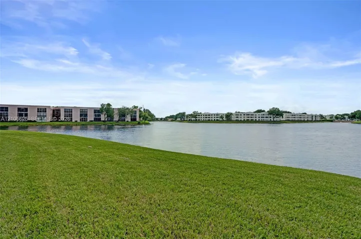 Expansive waterfront grounds featuring a manicured lawn and a wide water basin