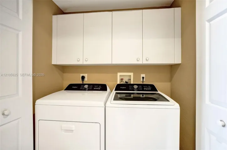 Built-in white overhead cabinetry and dual white folding closet doors