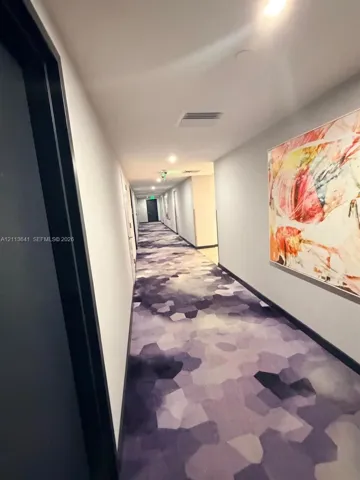 Hallway featuring recessed lighting and geometric-patterned carpeting