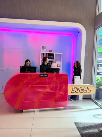 Custom-designed reception desk featuring a high-gloss finish, integrated accent lighting, and large-format floor​​‌​​​​‌​​‌‌​‌‌​​​‌‌​‌​‌​‌​​​‌​​ tiling