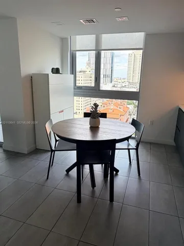 Large-format tile flooring, floor-to-ceiling windows with roller shades, and integrated cabinetry