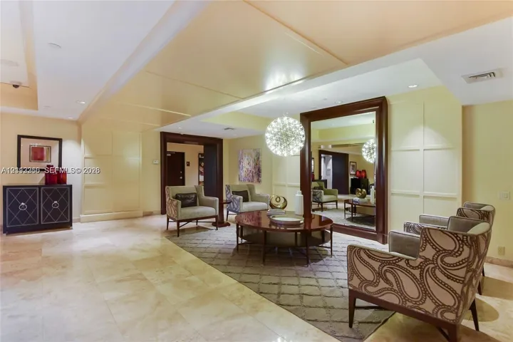 Large-format stone flooring, recessed lighting, millwork paneling, and a floor-to-ceiling framed mirror