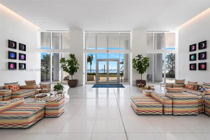 Grand lobby featuring high ceilings, expansive floor-to-ceiling windows, polished stone-finish flooring, and recessed cove lighting