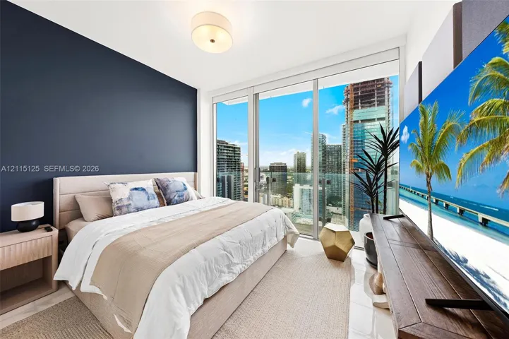 Floor-to-ceiling windows, glass-panel balcony, accent wall, and neutral tile flooring