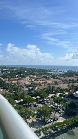 Elevated perspective featuring coastal horizon, mature tree canopy, and dedicated tennis court