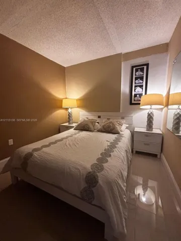 Neutral-toned walls paired with polished light-reflective flooring and a textured ceiling finish