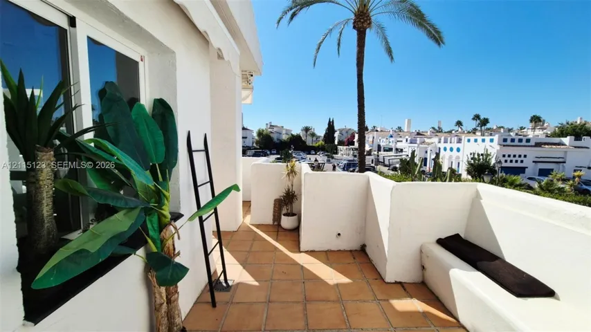 Terrace featuring terracotta tile flooring, built-in masonry bench seating, and stucco walls