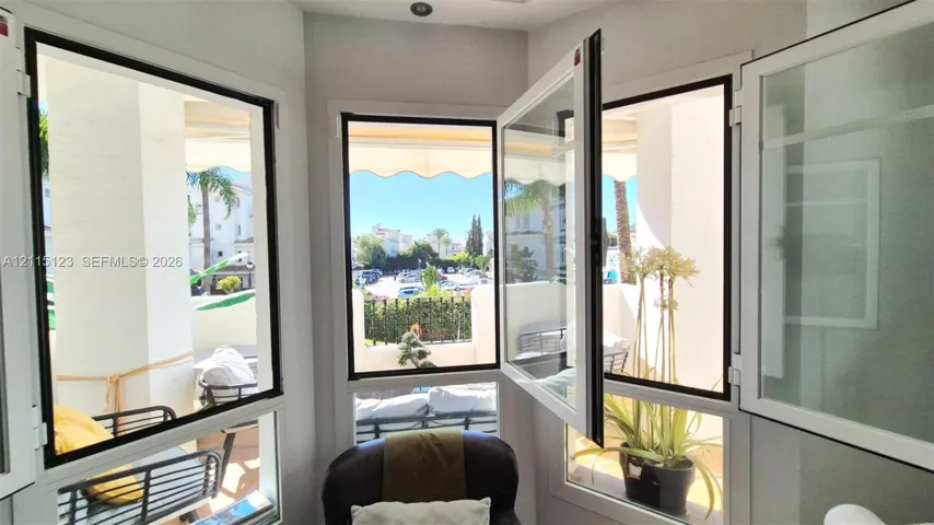 Multi-paneled casement windows with white frames featuring exterior access to a covered balcony