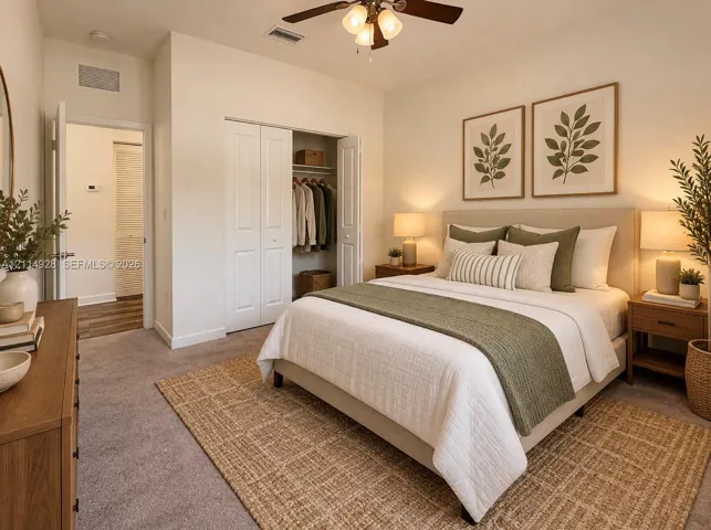 Neutral carpeting, ceiling fan with integrated lighting, and dual-door closet featuring built-in shelving